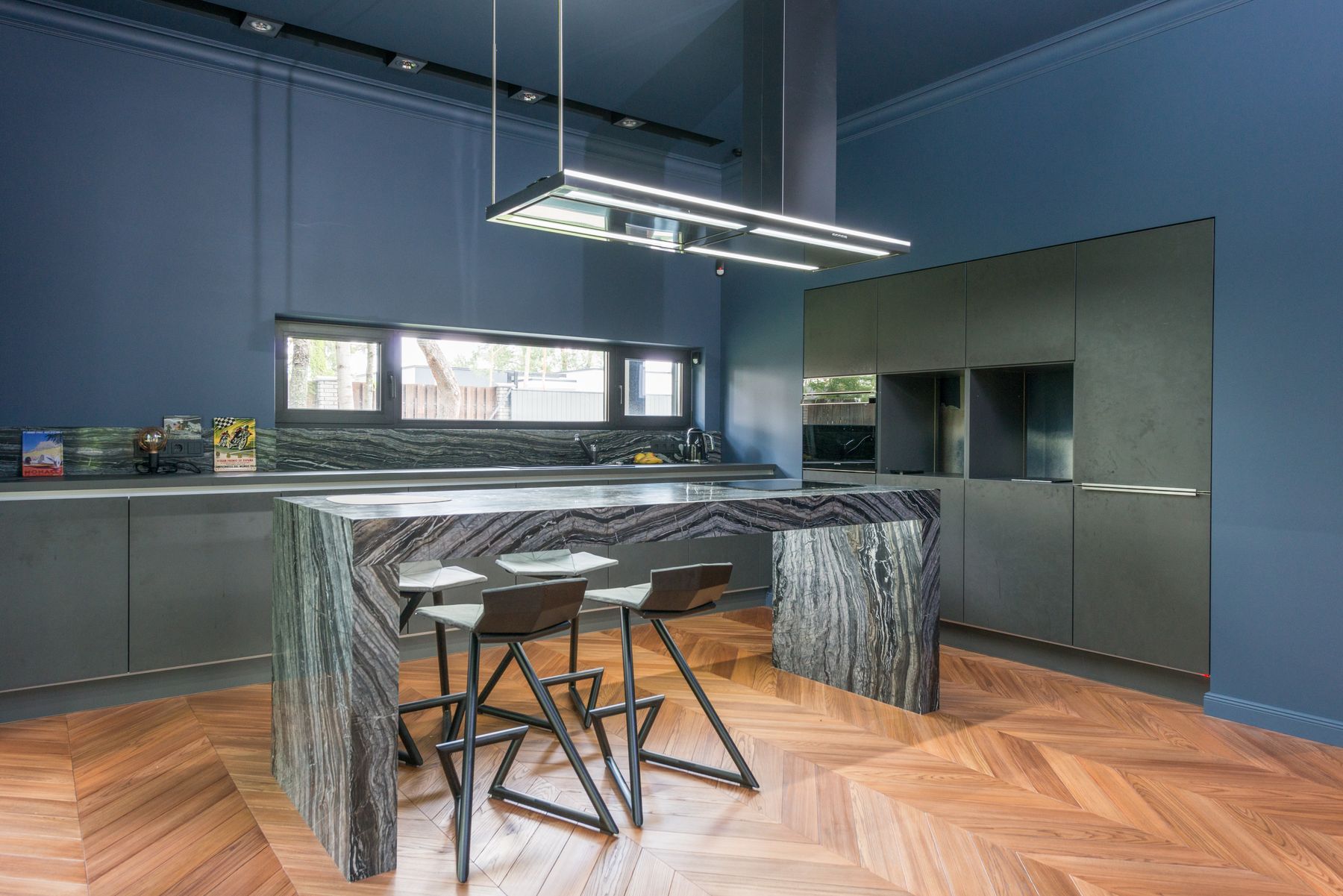 A blue modular kitchen with a granite island
